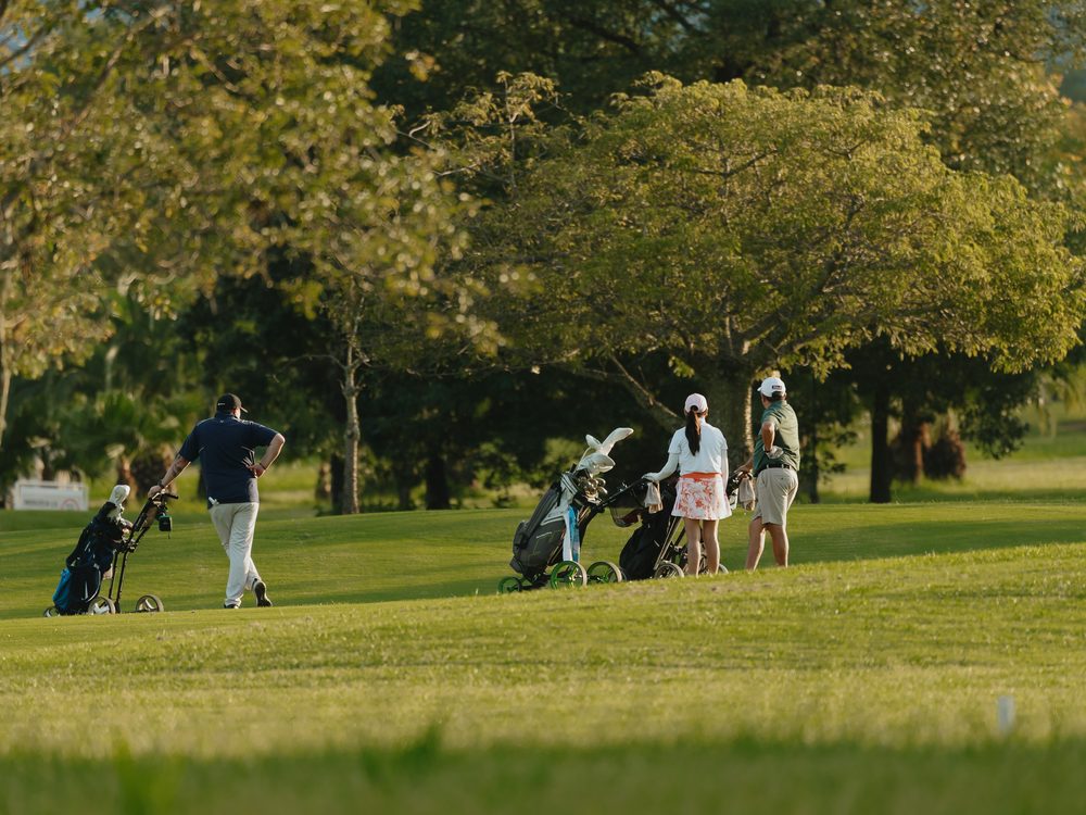 Vecinos jugando al golf en la cancha del country